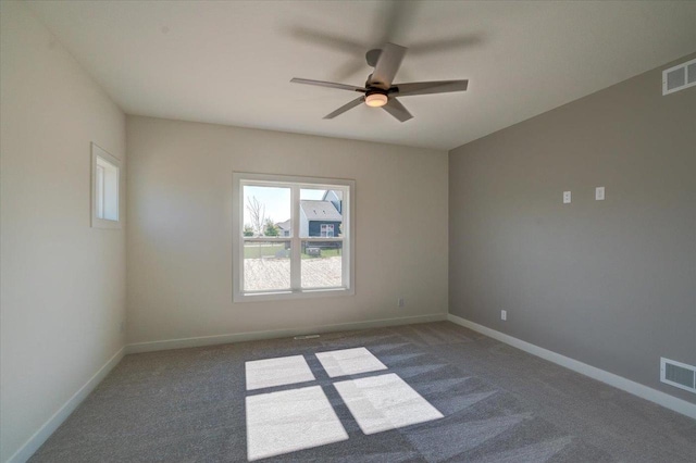 spare room with ceiling fan and dark carpet