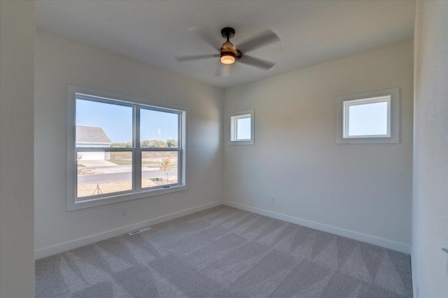 carpeted spare room featuring ceiling fan