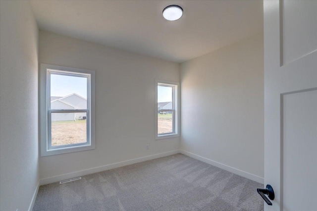 empty room featuring light carpet and a healthy amount of sunlight