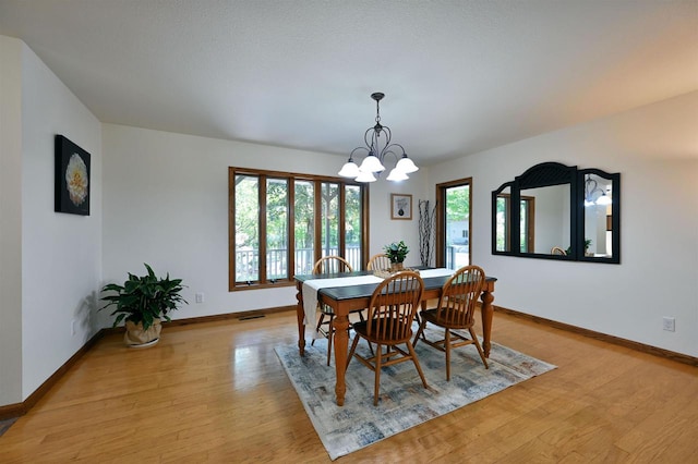 dining room with a notable chandelier and light hardwood / wood-style flooring