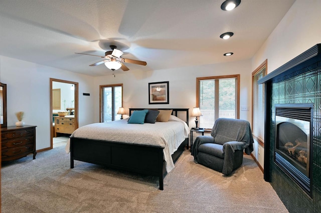 carpeted bedroom featuring ceiling fan and a fireplace