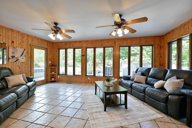 living room featuring wood walls and ceiling fan