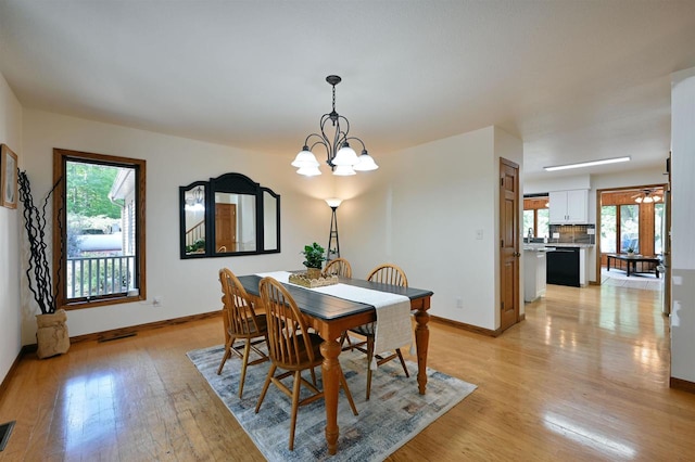 dining area featuring an inviting chandelier, light hardwood / wood-style floors, and a healthy amount of sunlight