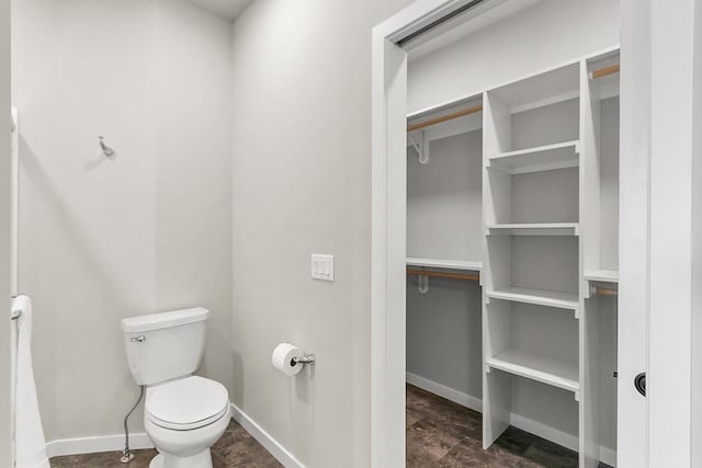 bathroom featuring baseboards and toilet