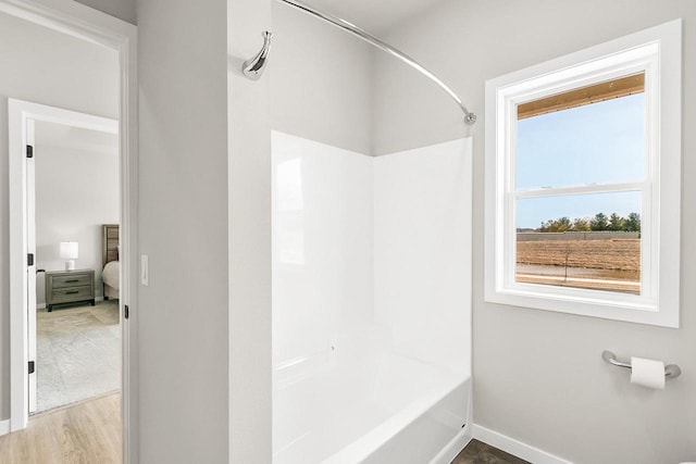 full bathroom featuring shower / bathtub combination, baseboards, and wood finished floors