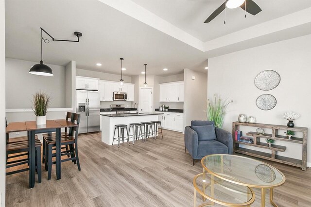 living area with recessed lighting, light wood finished floors, and ceiling fan