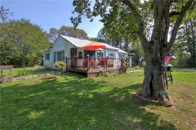 rear view of house featuring a yard and a deck