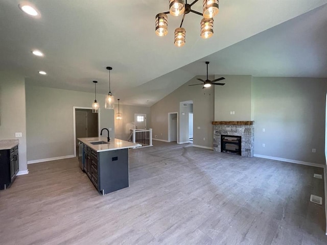 kitchen with hardwood / wood-style floors, a center island with sink, vaulted ceiling, and pendant lighting