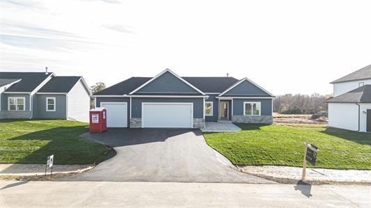 single story home with a garage and a front lawn