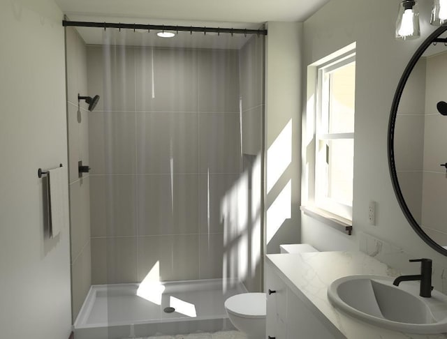 bathroom with tiled shower, vanity, and toilet