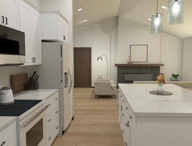 kitchen with lofted ceiling, white appliances, white cabinets, light wood-type flooring, and decorative light fixtures