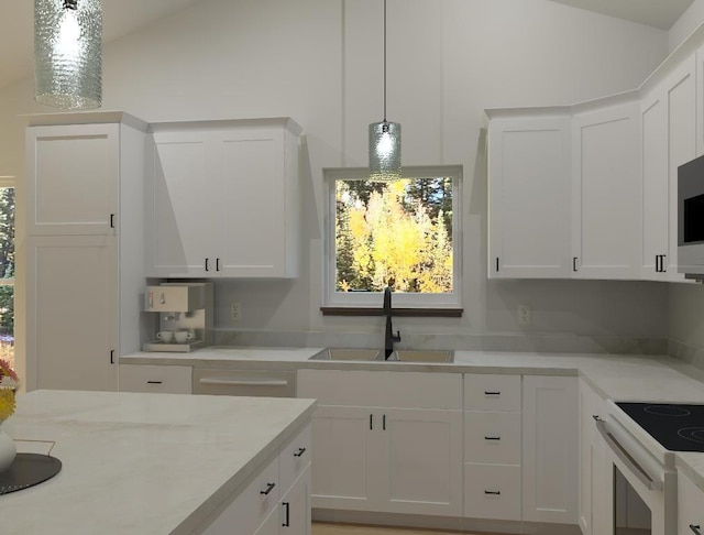 kitchen with white cabinetry, lofted ceiling, and sink