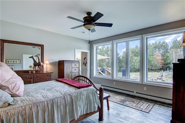 6030 Mitchell Rd, Iron River, WI 54847 - bedroom with a ceiling fan, wood finished floors, and baseboard heating