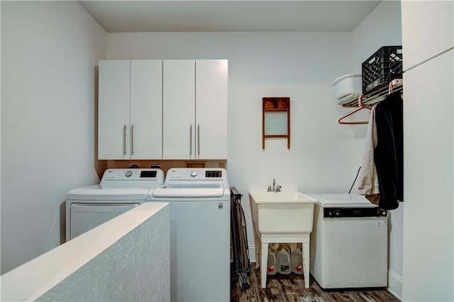 clothes washing area with cabinets, independent washer and dryer, and dark wood-type flooring