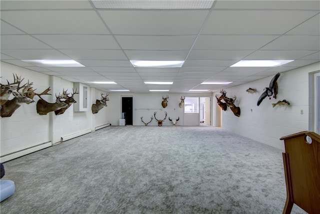 basement with carpet floors, a baseboard radiator, and a paneled ceiling