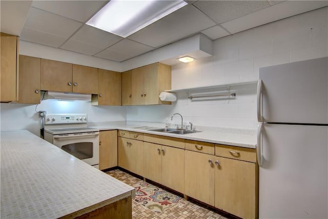 kitchen with white appliances, sink, and a drop ceiling