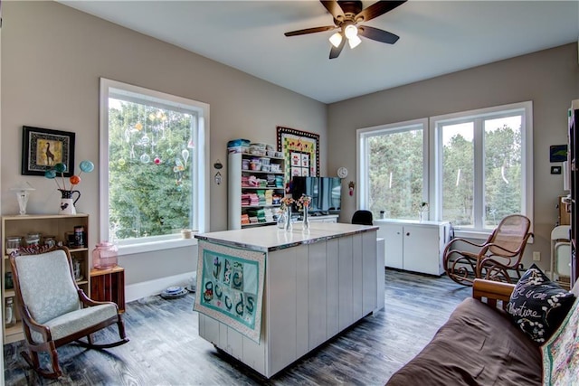 office with dark wood-type flooring, ceiling fan, and a healthy amount of sunlight