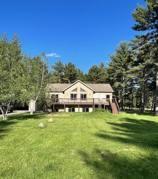 rear view of house with a deck and a lawn