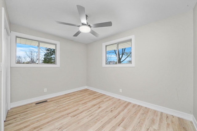 spare room featuring ceiling fan, light hardwood / wood-style floors, and plenty of natural light