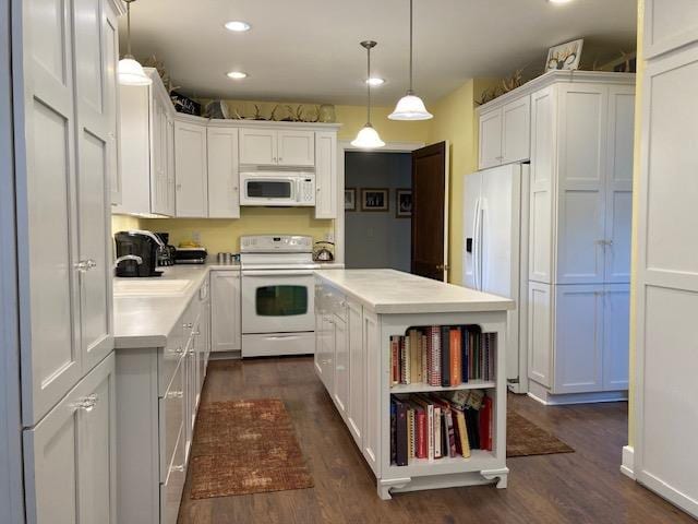 kitchen featuring white appliances, white cabinetry, dark hardwood / wood-style flooring, and pendant lighting