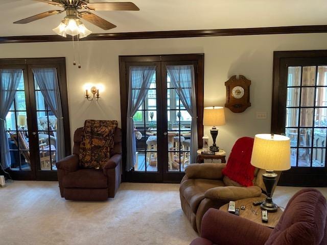 living room with french doors, light carpet, ornamental molding, and ceiling fan