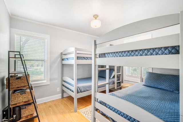 bedroom with multiple windows, crown molding, lofted ceiling, and hardwood / wood-style flooring