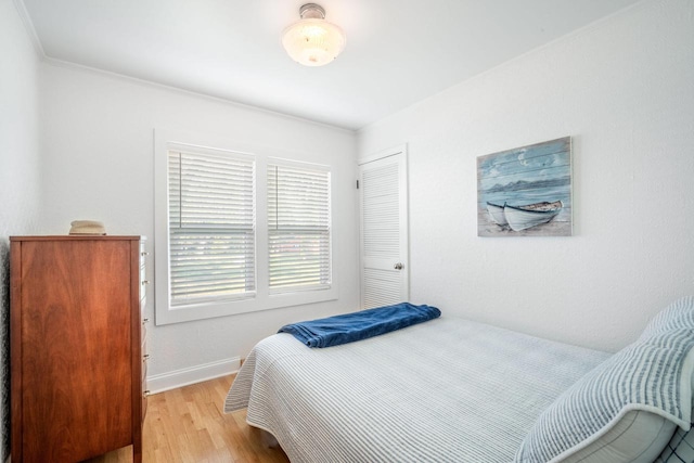 bedroom with light hardwood / wood-style flooring and crown molding