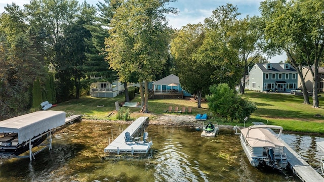 view of dock with a yard and a water view