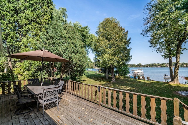 wooden terrace with a water view and a yard