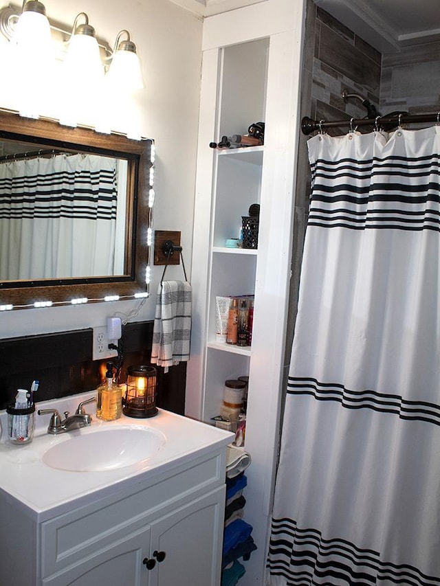 bathroom with curtained shower, vanity, and crown molding