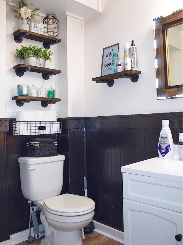 bathroom with hardwood / wood-style floors, vanity, and toilet