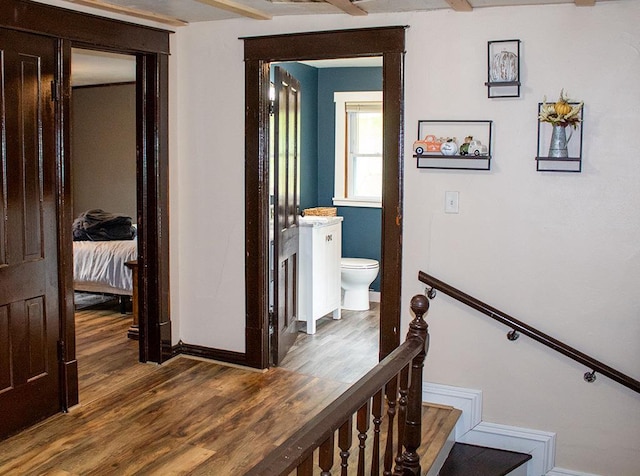 hall with beam ceiling and dark hardwood / wood-style floors