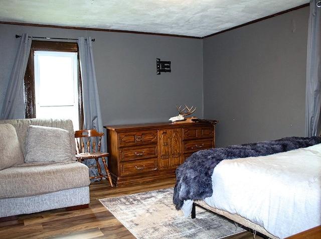 bedroom featuring ornamental molding and dark wood-type flooring