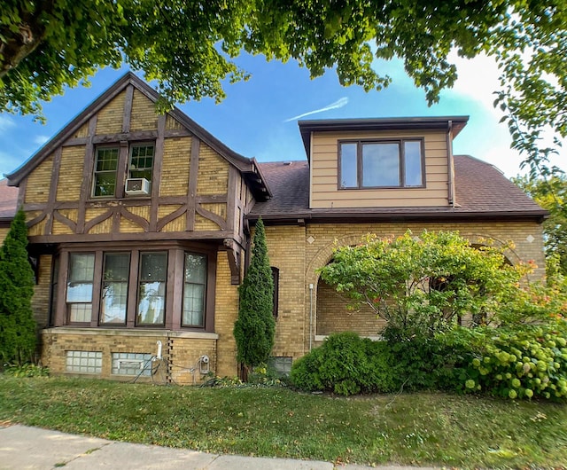 view of front of property featuring a front yard and cooling unit