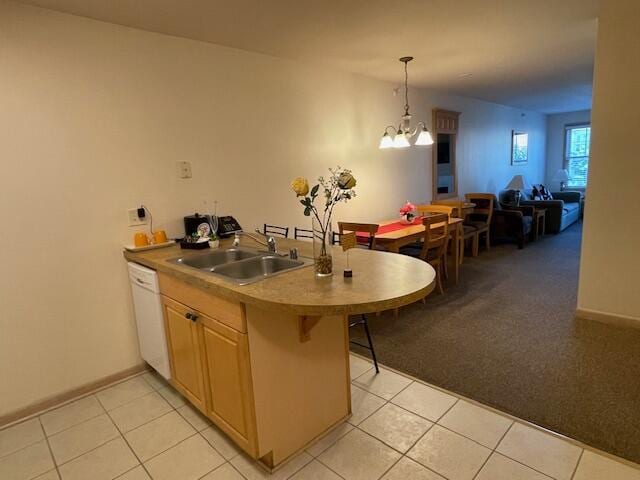 kitchen featuring white dishwasher, hanging light fixtures, light tile patterned floors, sink, and a kitchen breakfast bar