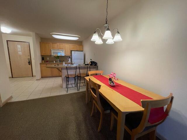 dining area with an inviting chandelier and light tile patterned floors