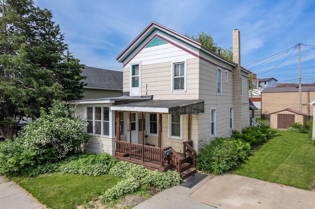 view of front of house featuring a front yard and a shed