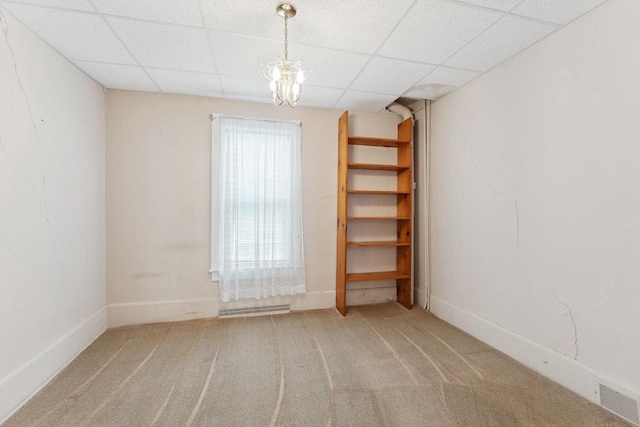 carpeted spare room with a paneled ceiling