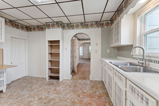 kitchen featuring white cabinets, a paneled ceiling, and sink