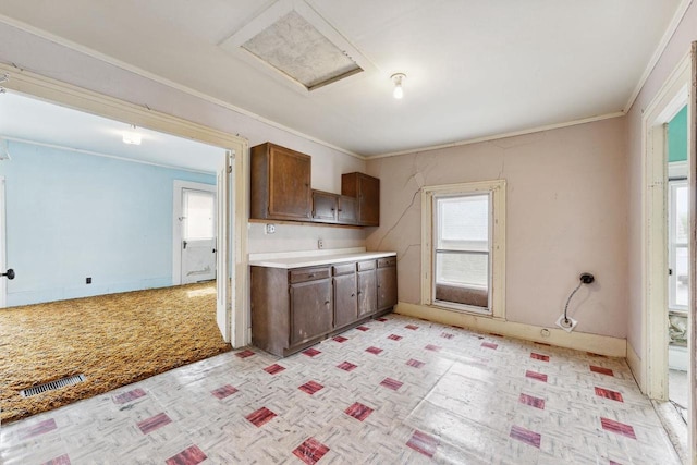 kitchen featuring ornamental molding and light colored carpet