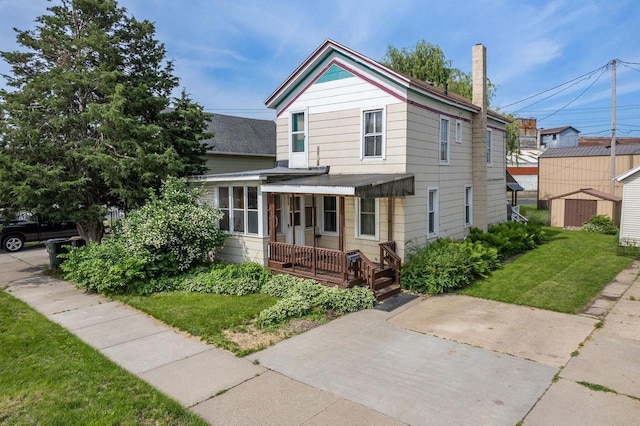 view of front of property featuring a storage shed, a porch, and a front yard