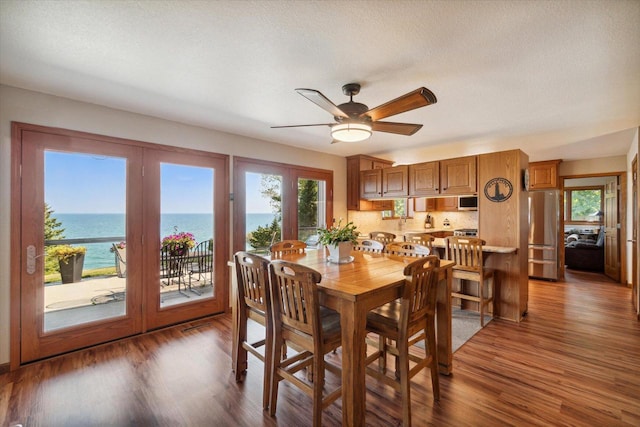7001 Novak Rd, Racine, WI 53402 - dining room with wood finished floors, a ceiling fan, french doors, and a water view