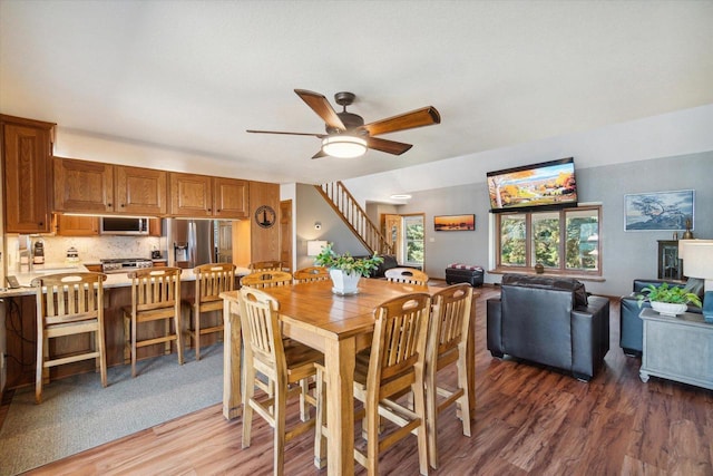 7001 Novak Rd, Racine, WI 53402 - dining room featuring light wood-style flooring, ceiling fan, and stairs
