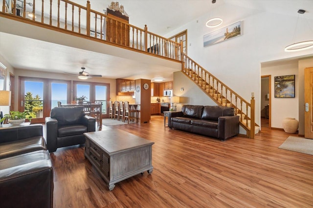 7001 Novak Rd, Racine, WI 53402 - living room with wood finished floors, a high ceiling, stairs, and ceiling fan