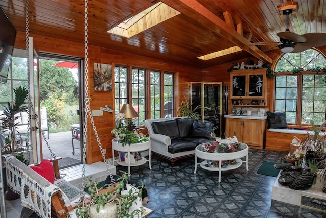 sunroom featuring wood ceiling, ceiling fan, and vaulted ceiling with skylight