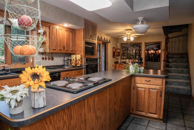 kitchen with ceiling fan, sink, dark tile patterned floors, a textured ceiling, and black appliances