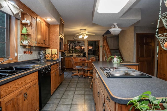 kitchen with a center island, black appliances, sink, ceiling fan, and a textured ceiling