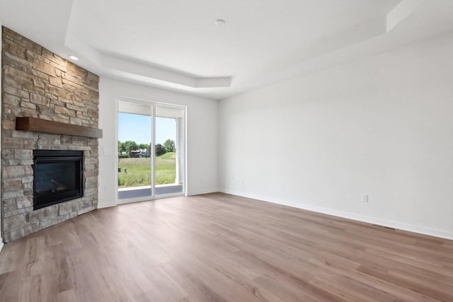 508 Hickory Hollow Rd Unit 0202, Waterford, WI 53185 - unfurnished living room with a raised ceiling, a fireplace, and light hardwood / wood-style flooring