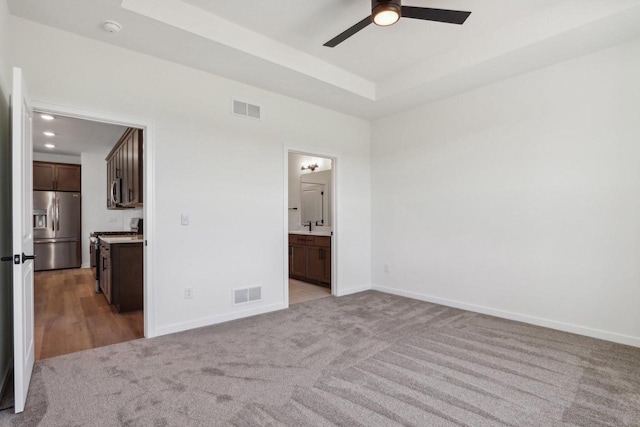 508 Hickory Hollow Rd Unit 0202, Waterford, WI 53185 - unfurnished bedroom featuring ensuite bathroom, stainless steel fridge with ice dispenser, light colored carpet, and ceiling fan