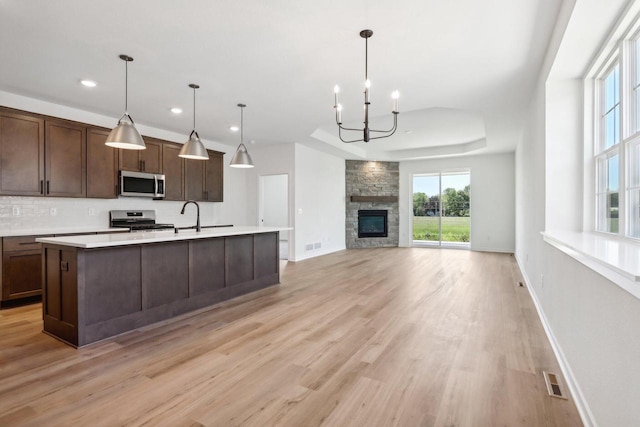 508 Hickory Hollow Rd Unit 0202, Waterford, WI 53185 - kitchen featuring a stone fireplace, stainless steel appliances, plenty of natural light, and a chandelier